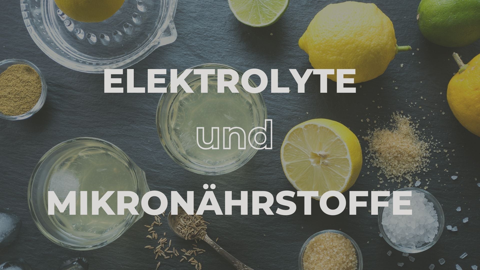 > Natürliche Quellen für Elektrolyte und Mikronährstoffe – Zitronen, Salz und Körner auf einem dunklen Untergrund